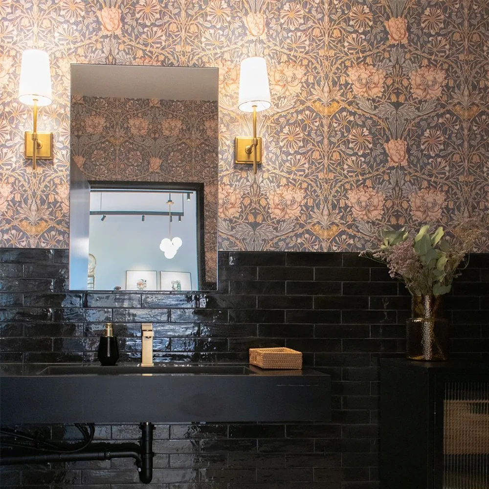 Bathroom with William Morris Honeysuckle wallpaper and black tile.