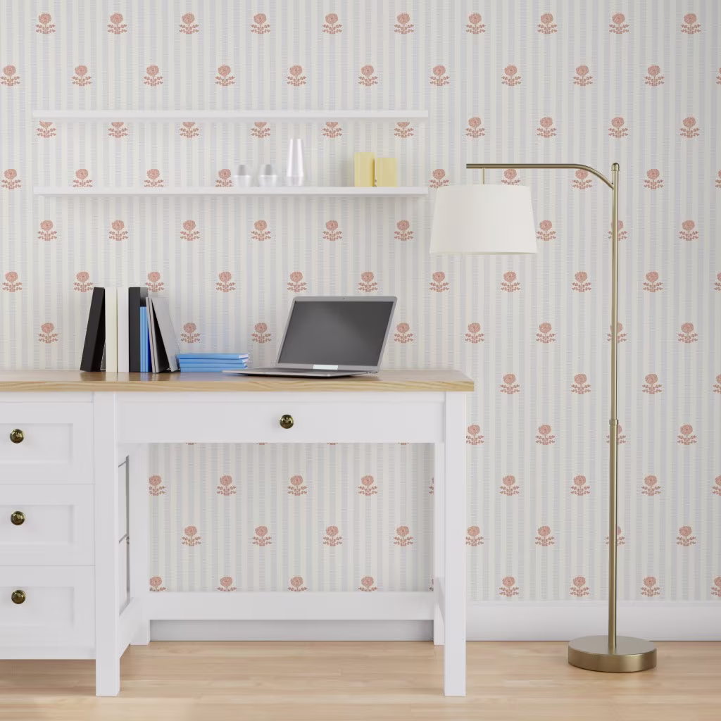 Office space with wallpaper printed with blue stripes and pink block print florals.