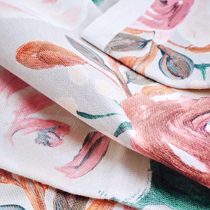 Stack of folded fabric pieces in various colors and geometric, botanical, and abstract patterns arranged in a tall pile.