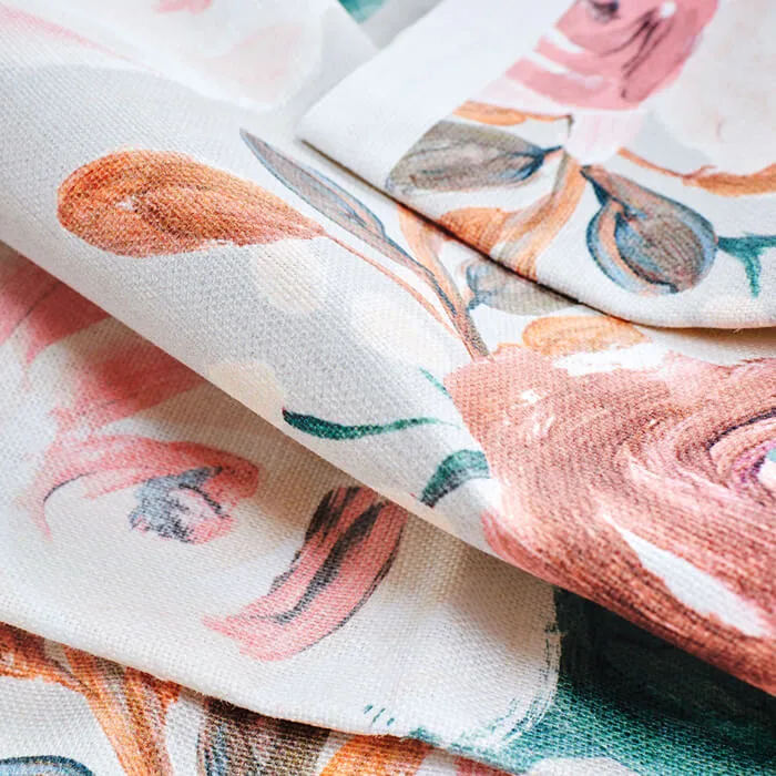 Stack of folded fabric pieces in various colors and geometric, botanical, and abstract patterns arranged in a tall pile.