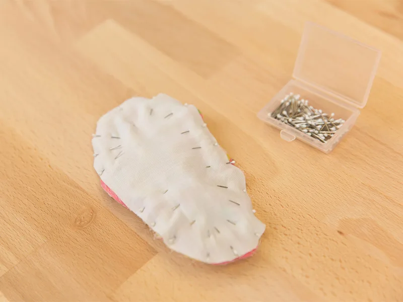 The baby shoe bottom pieces are pinned together.