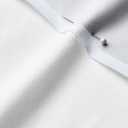 A close-up photo of white fabric with a pin running through it