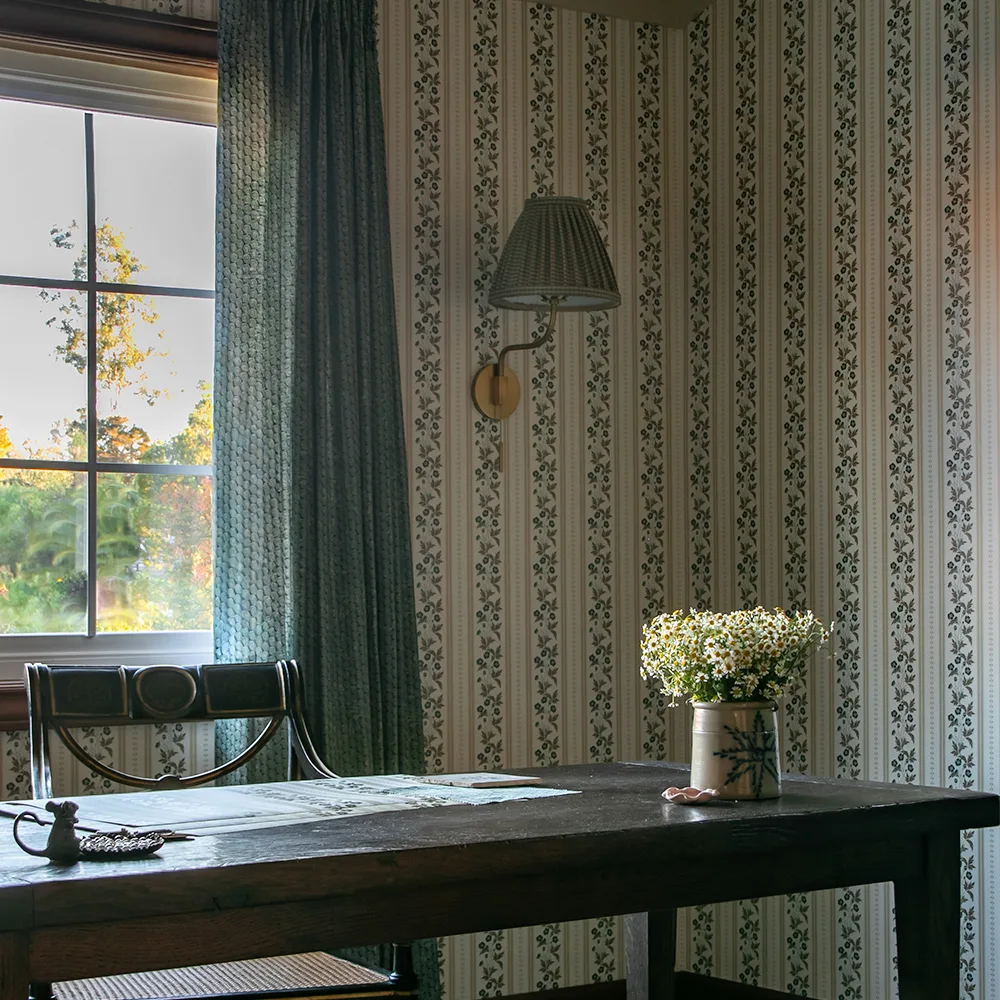 Home office with floral stripe wallpaper.