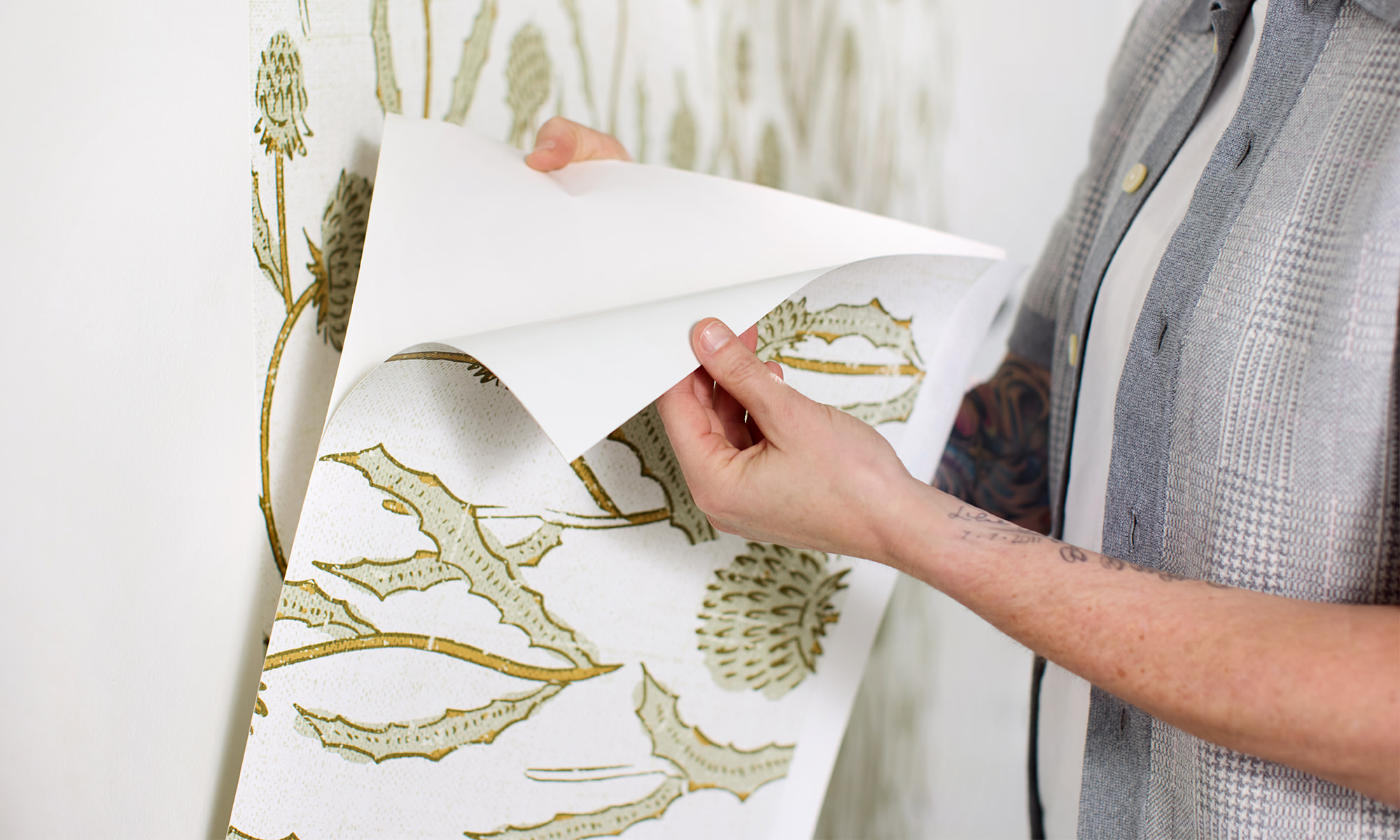 Person peeling apart Peel and Stick wallpaper.