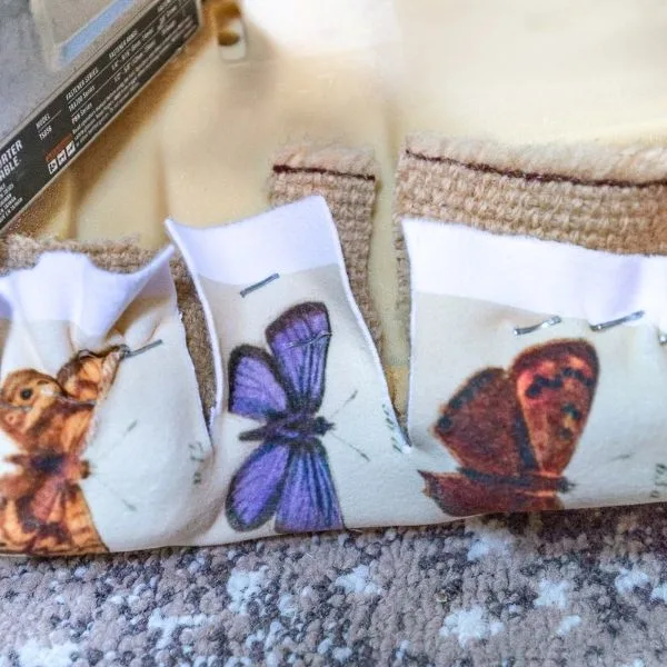 Upholstery fabric stapled to corner of chair