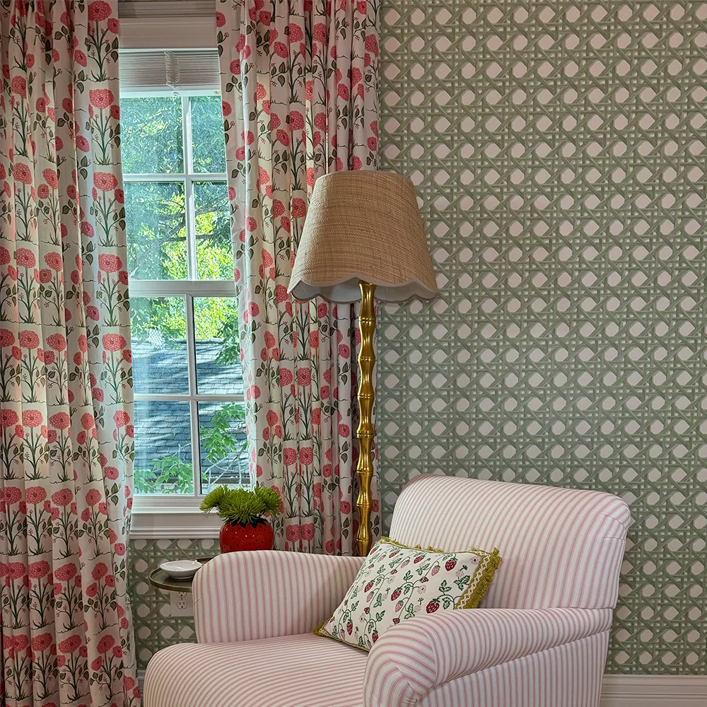 Living space with green trellis wallpaper and floral curtains.