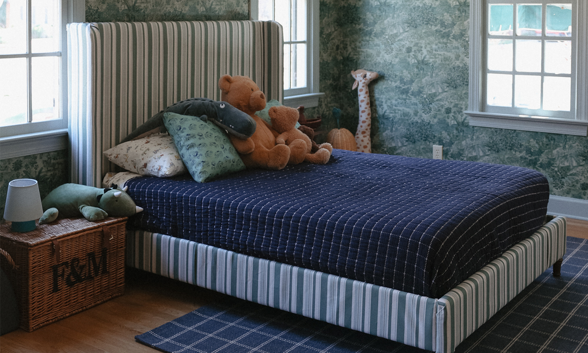 Boys room with a bed frame covered in stripe fabric.