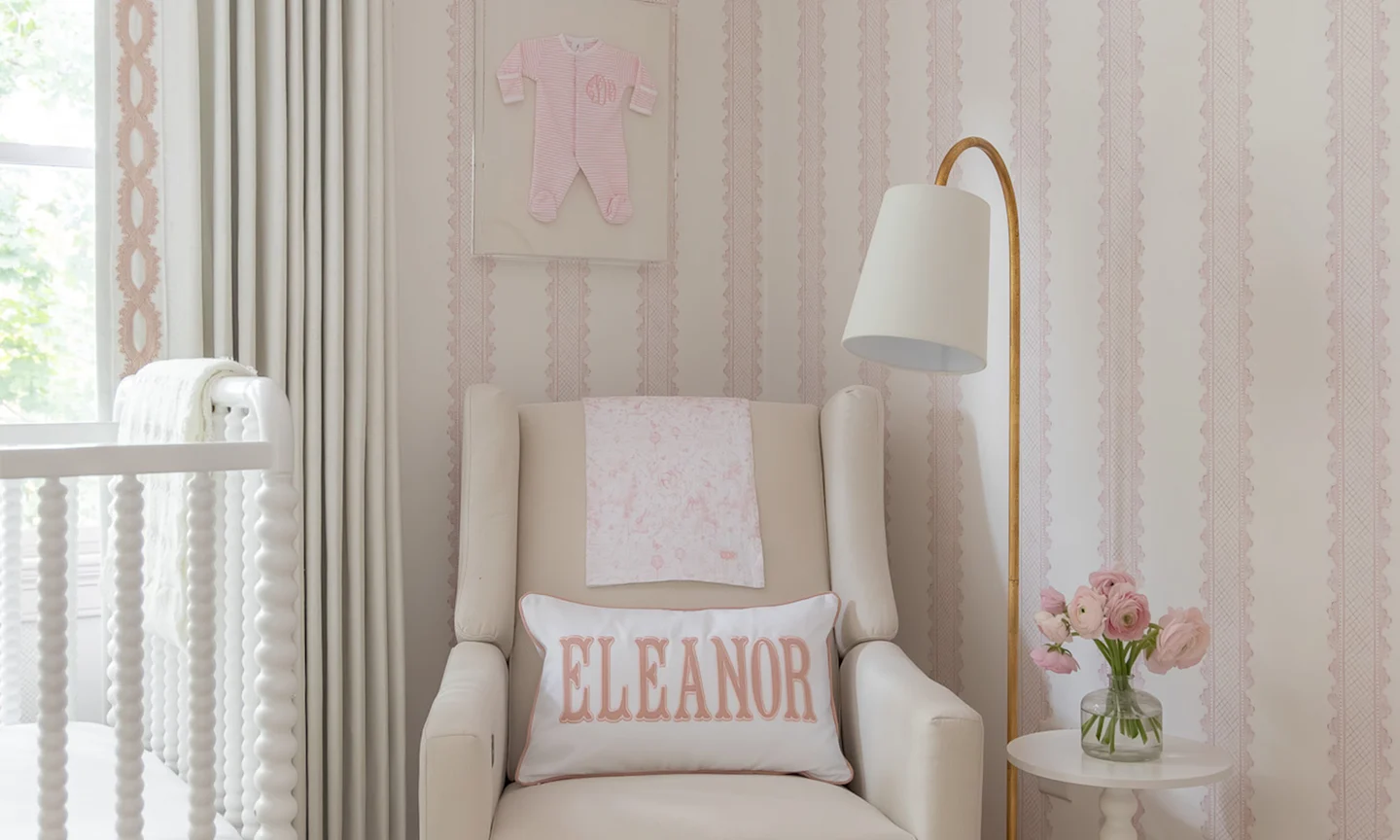 Nursery with pink stripe wallpaper.