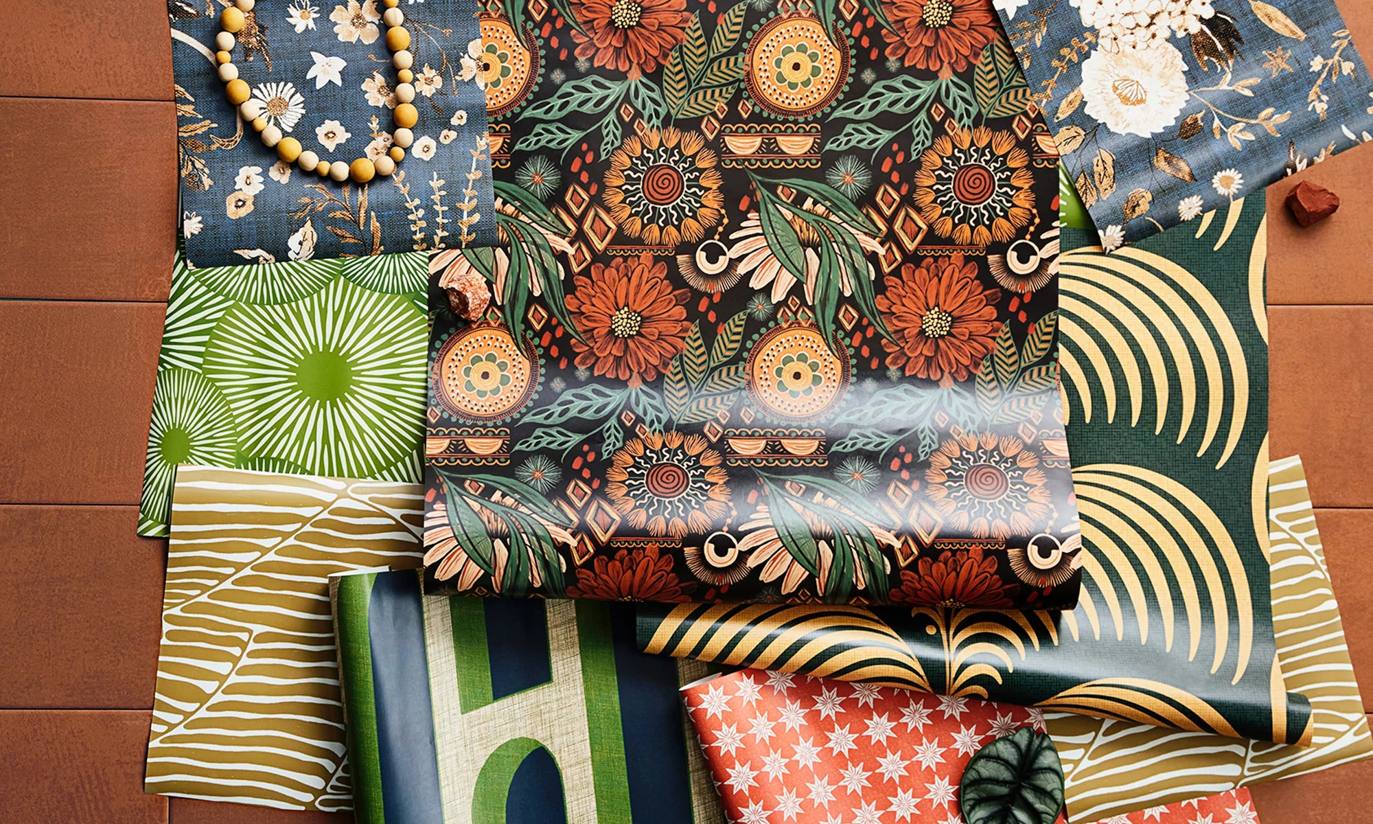 Boho peel and stick wallpaper rolls and swatches styled together.