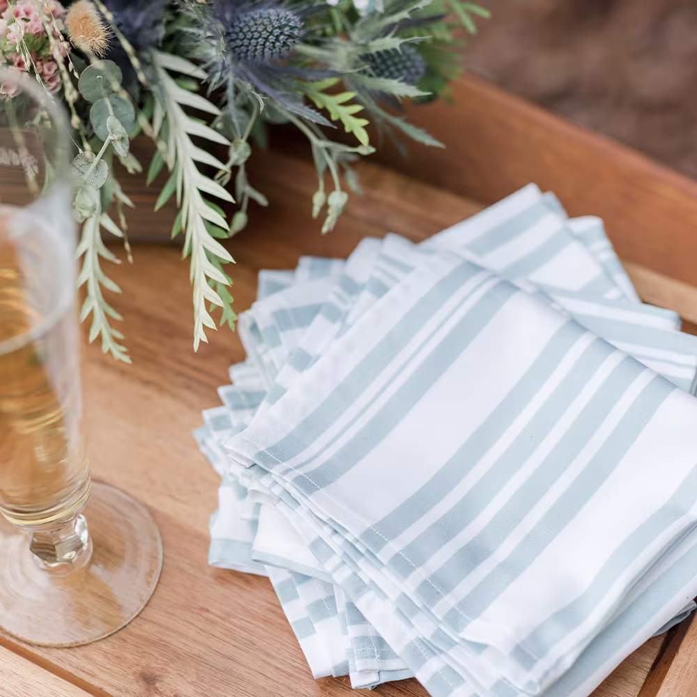 Two sets of cocktail napkins on table with lemon slices