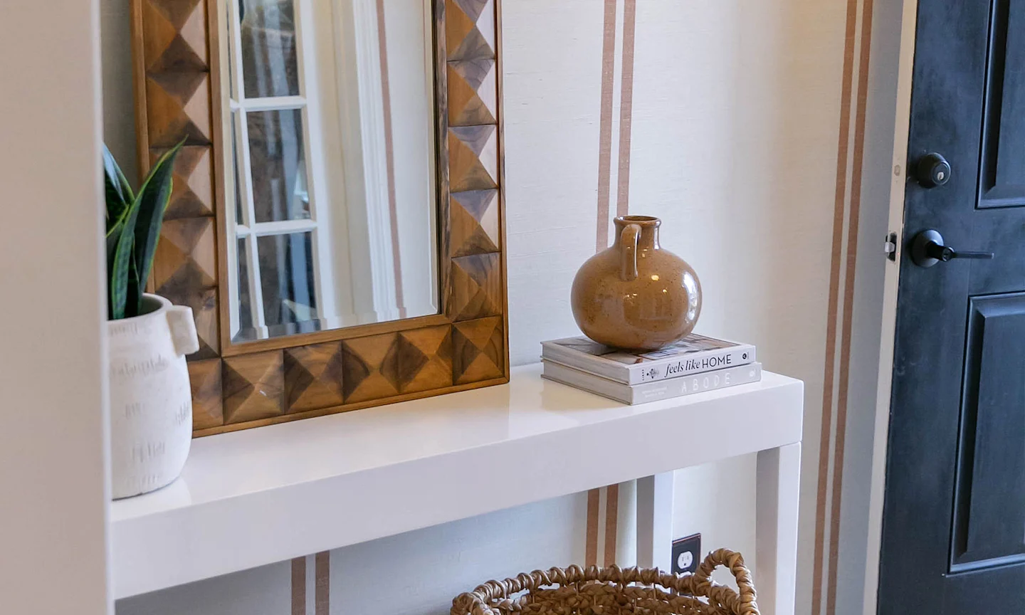 An entryway wallpapered in traditional brown striped wallpaper.