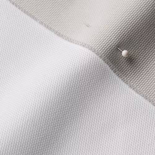 A close-up photo of white fabric with a pin running through it