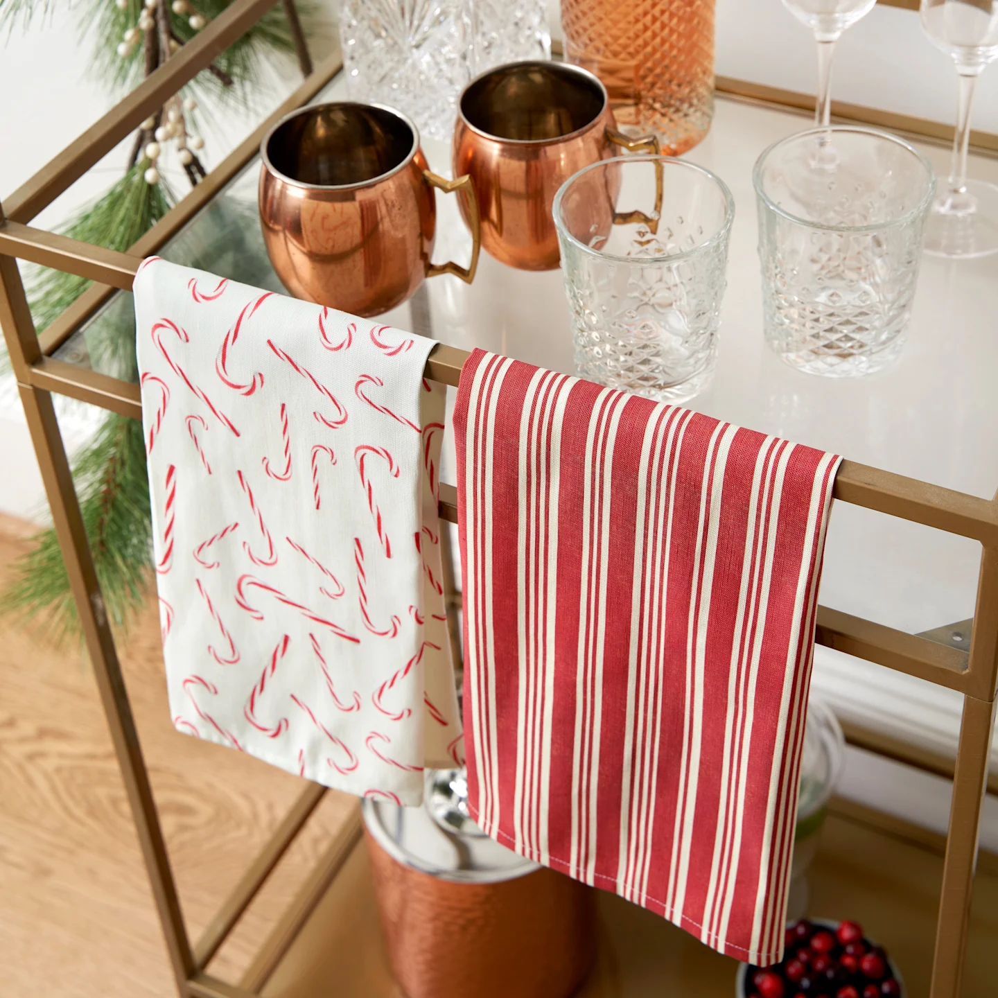Colorful holiday tea towels hanging from a bar cart