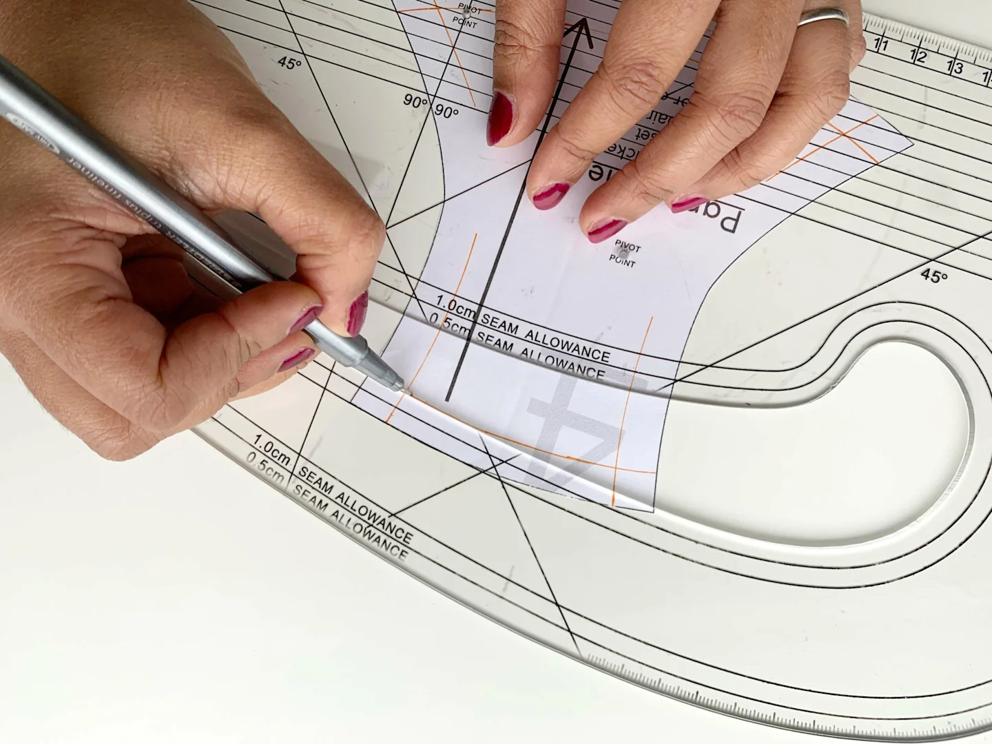 Drafting the new underwear pattern by marking stitch lines on the paper