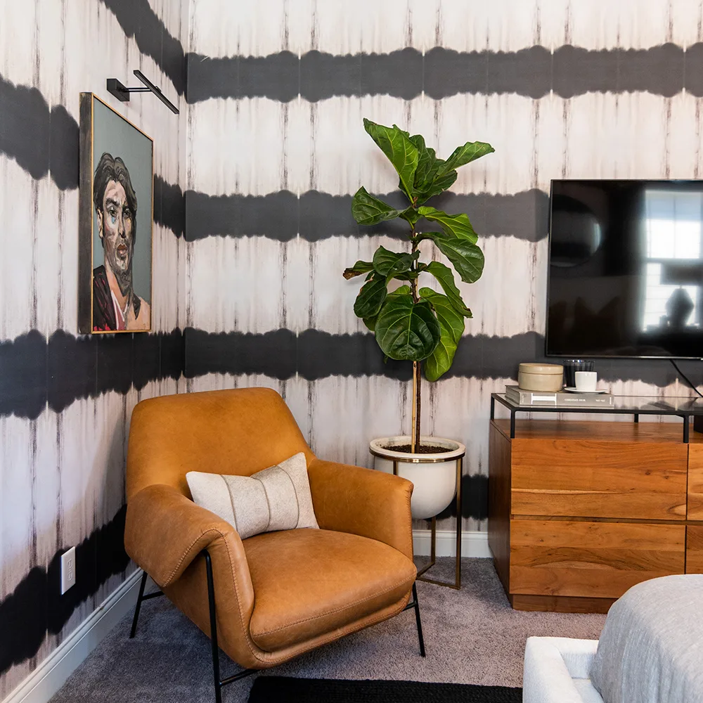 Bedroom with black and white stripe wallpaper.
