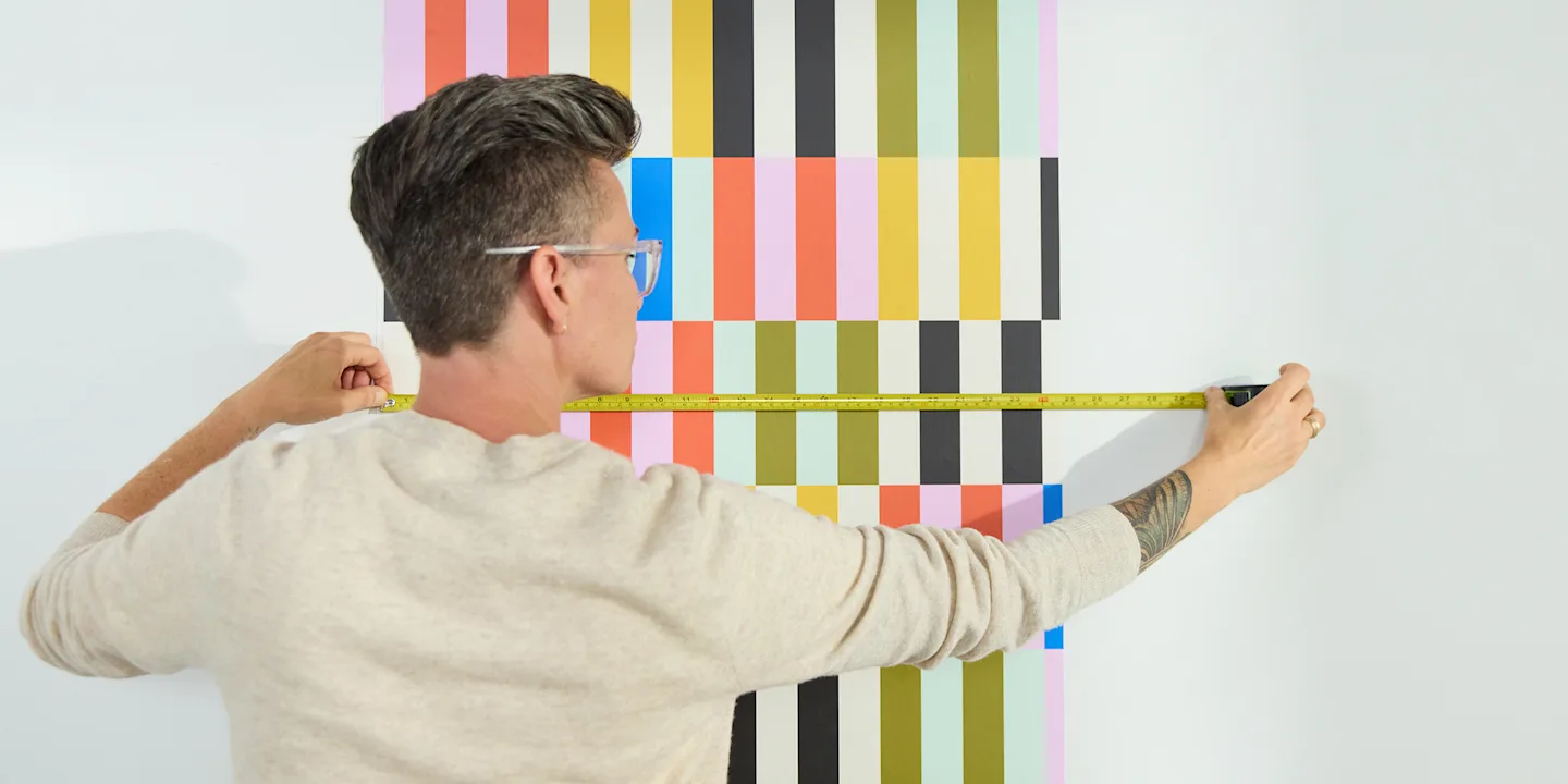 Person measuring the repeat on a roll of wallpaper.