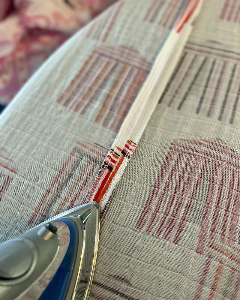 Pressing a seam of the caftan with an iron.