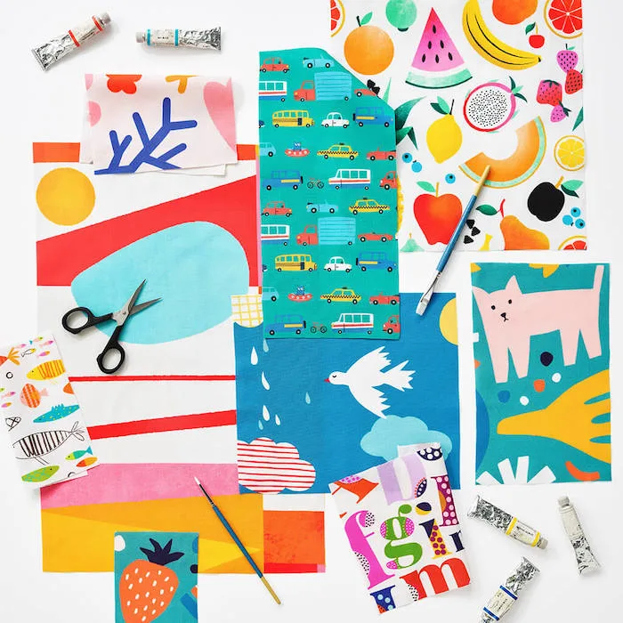A flat lay of colorful fabric swatches with bold, playful designs, including fruit, animals, abstract shapes, vehicles, and graphic patterns.