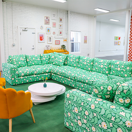 Mint green floral sectional couch in a Space Camp Organizing workspace.
