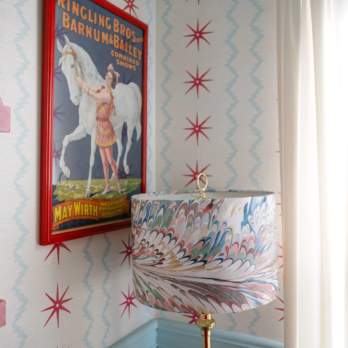 Close up of lamp, circus poster, and wallpaper