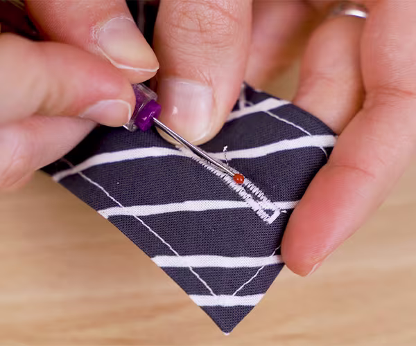 Creating a buttonhole at the top of one of the craft organizer straps.
