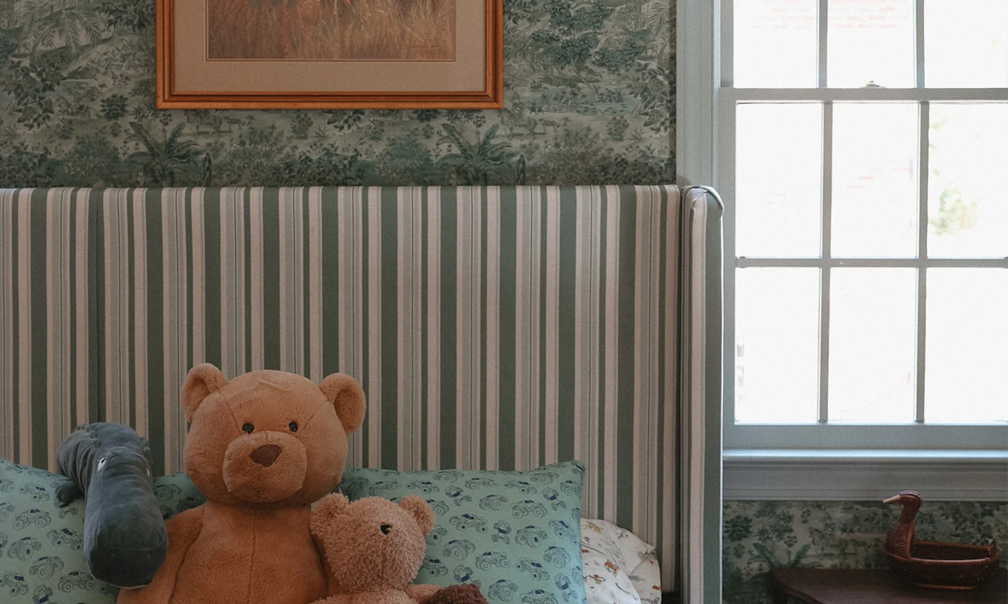 Boys room with a bed frame covered in stripe fabric.