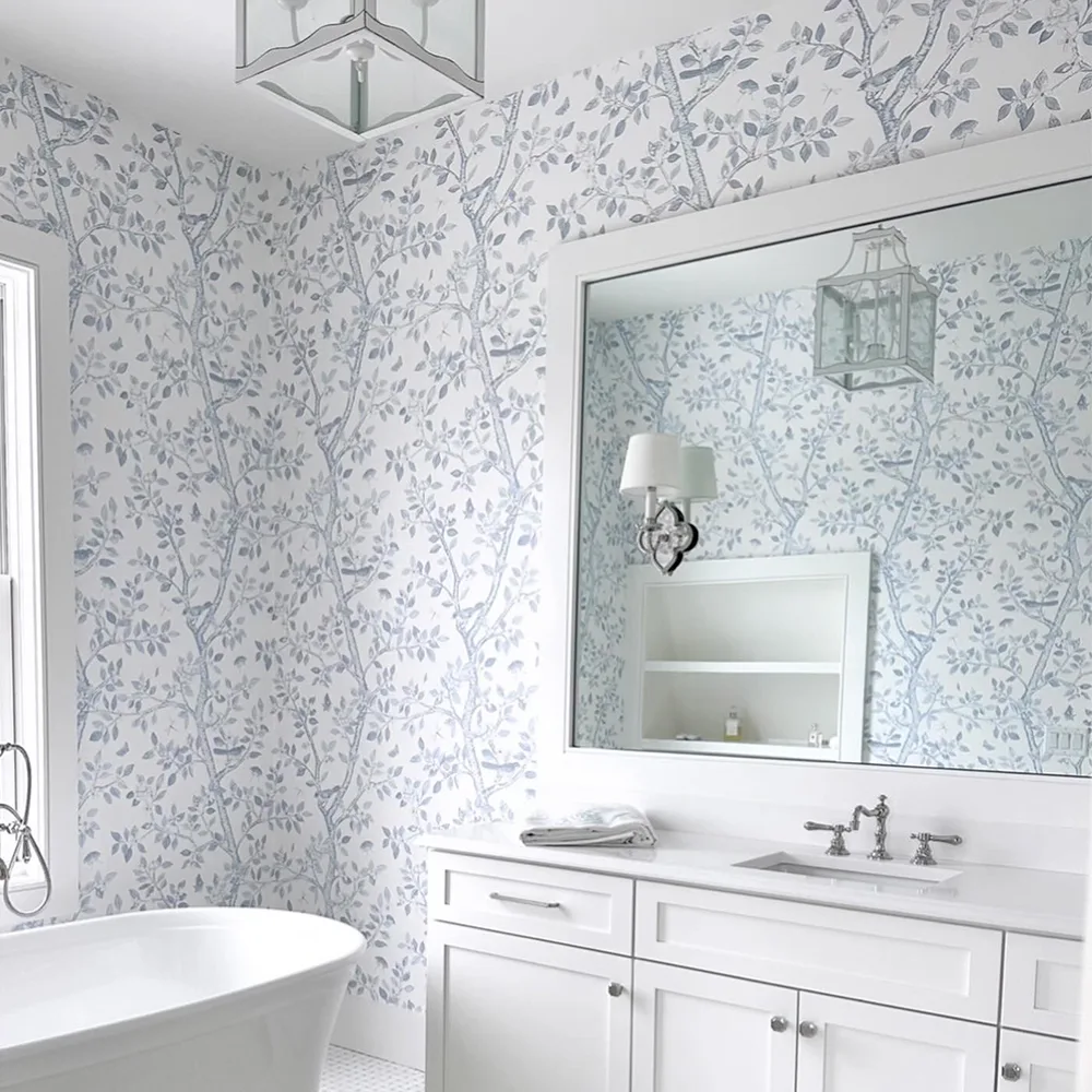Bathroom with white and blue branch wallpaper.