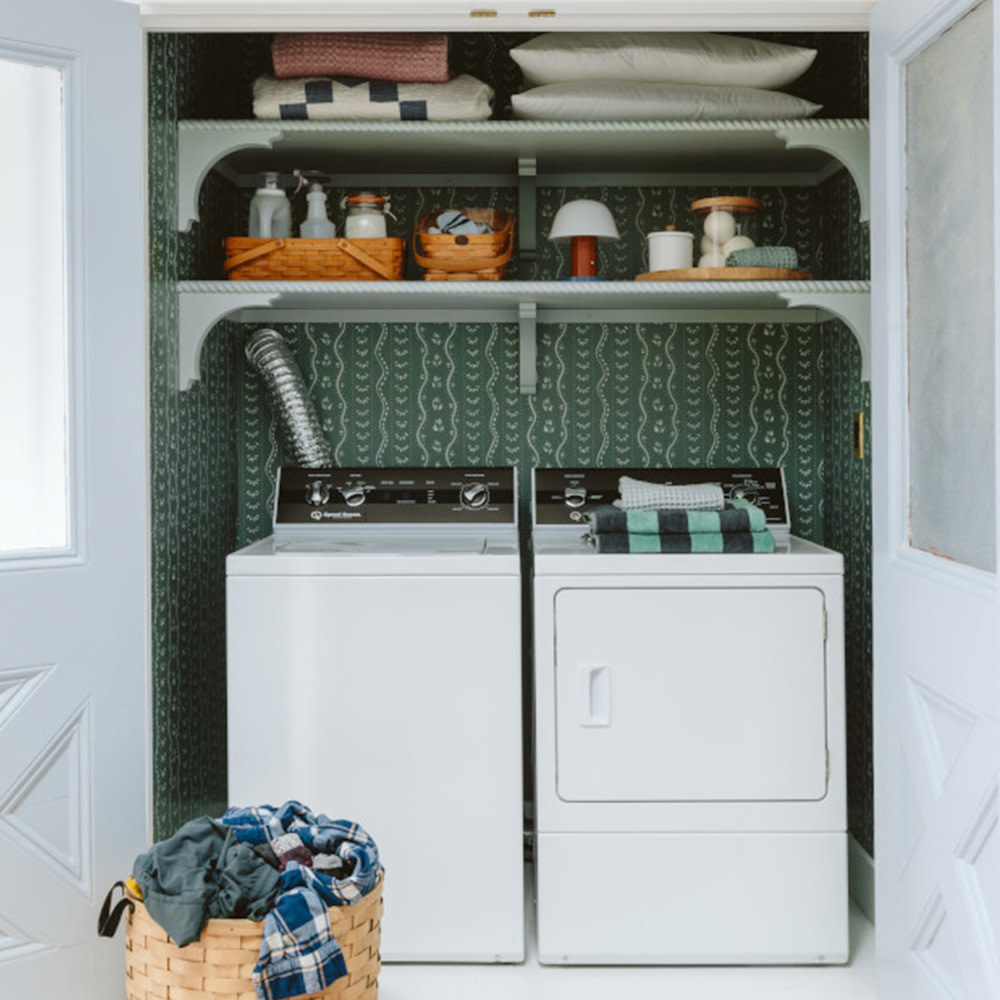 Pine green striped wallpaper in a laundry closet.