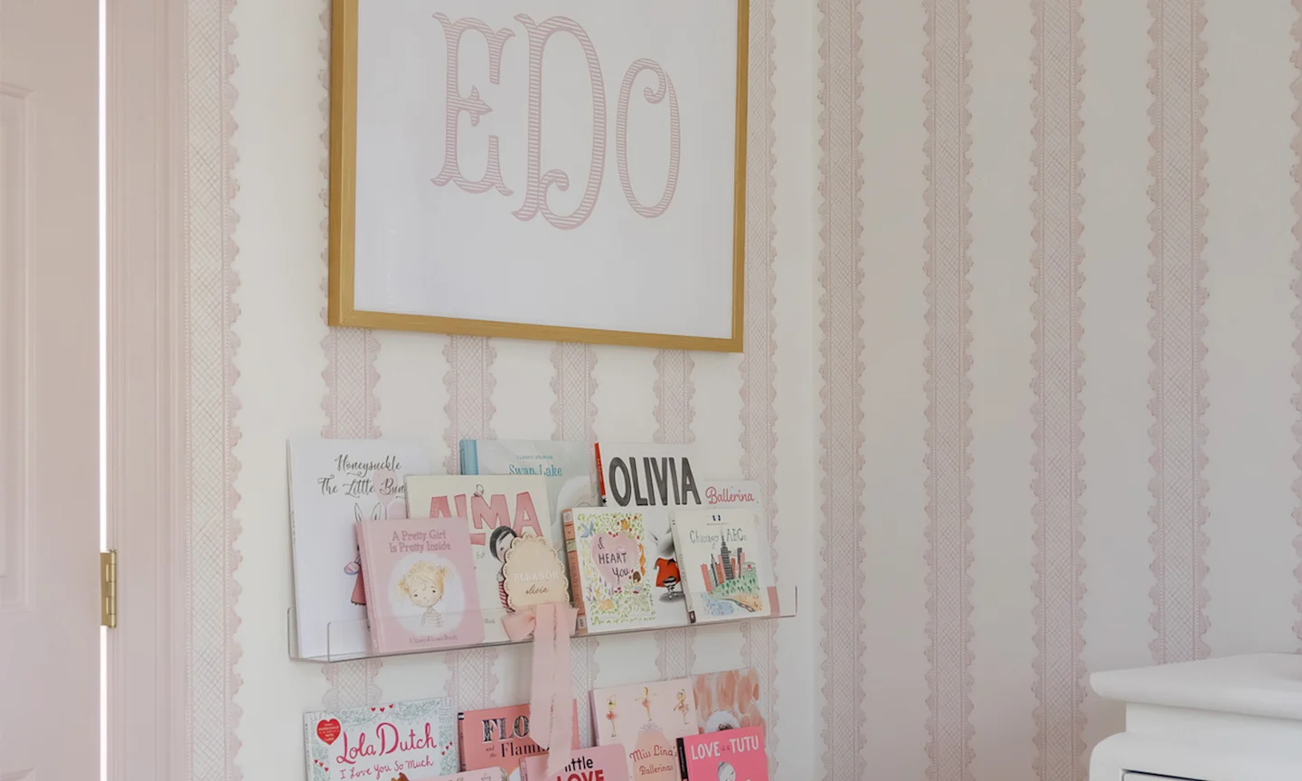 Nursery with pink stripe wallpaper.