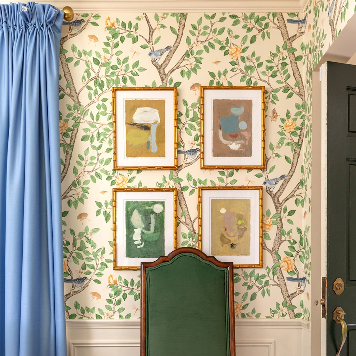 Dining area with Wallpaper in Elsie's Garden Butterscotch on cream, blue curtains and a green dining chair.