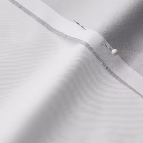 A close-up photo of white fabric with a pin running through it
