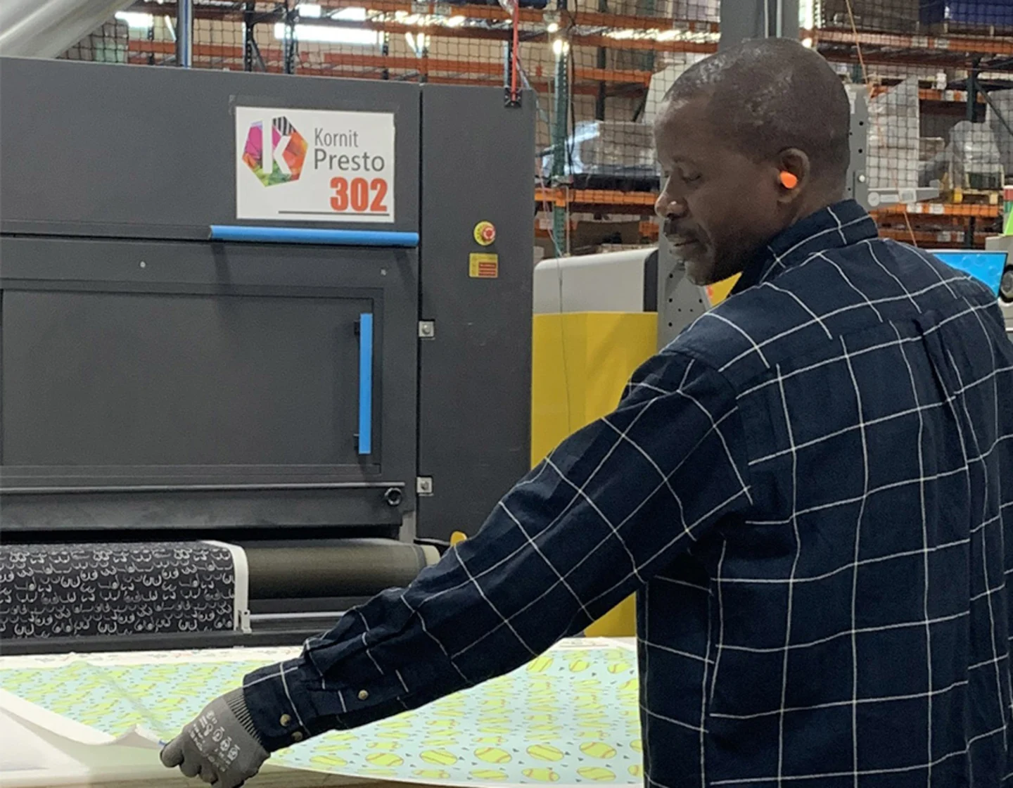 man pulling printed fabric from Kornit printer