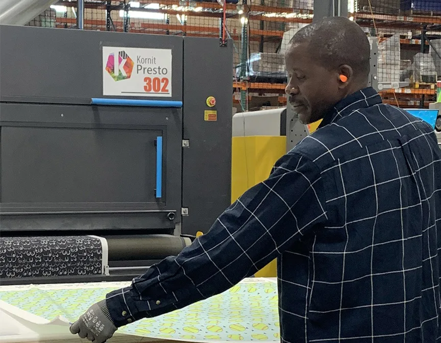 man pulling printed fabric from Kornit printer
