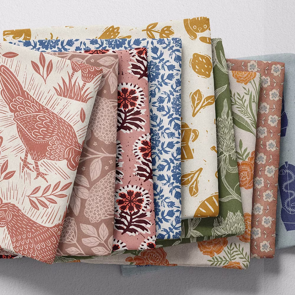 Stack of folksy block print design fabrics.