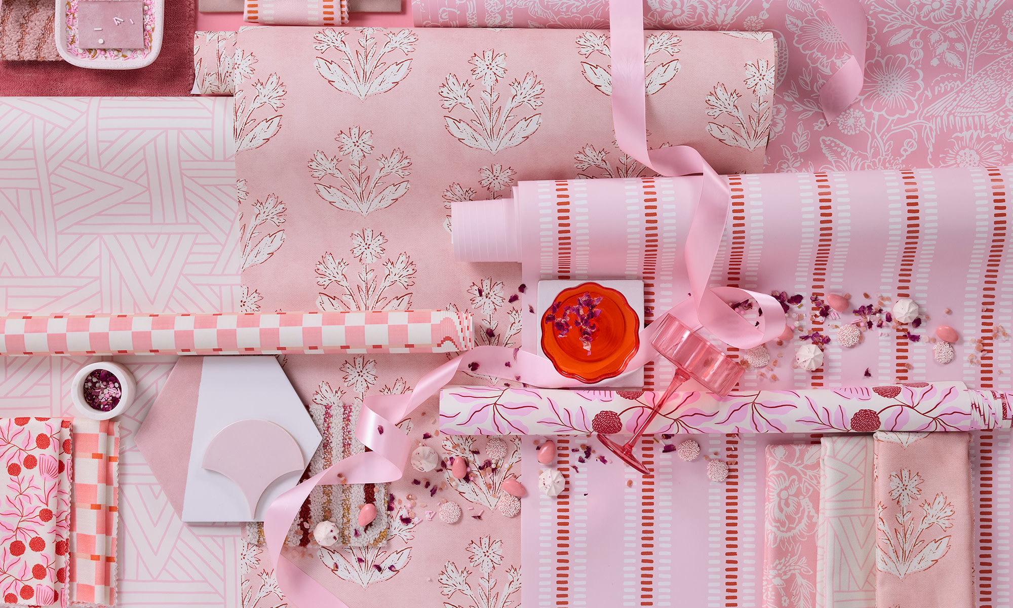 Pink rolls of wallpaper on a pink background.