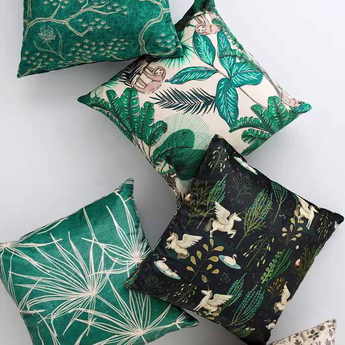 Five decorative throw pillows with botanical and nature-inspired patterns