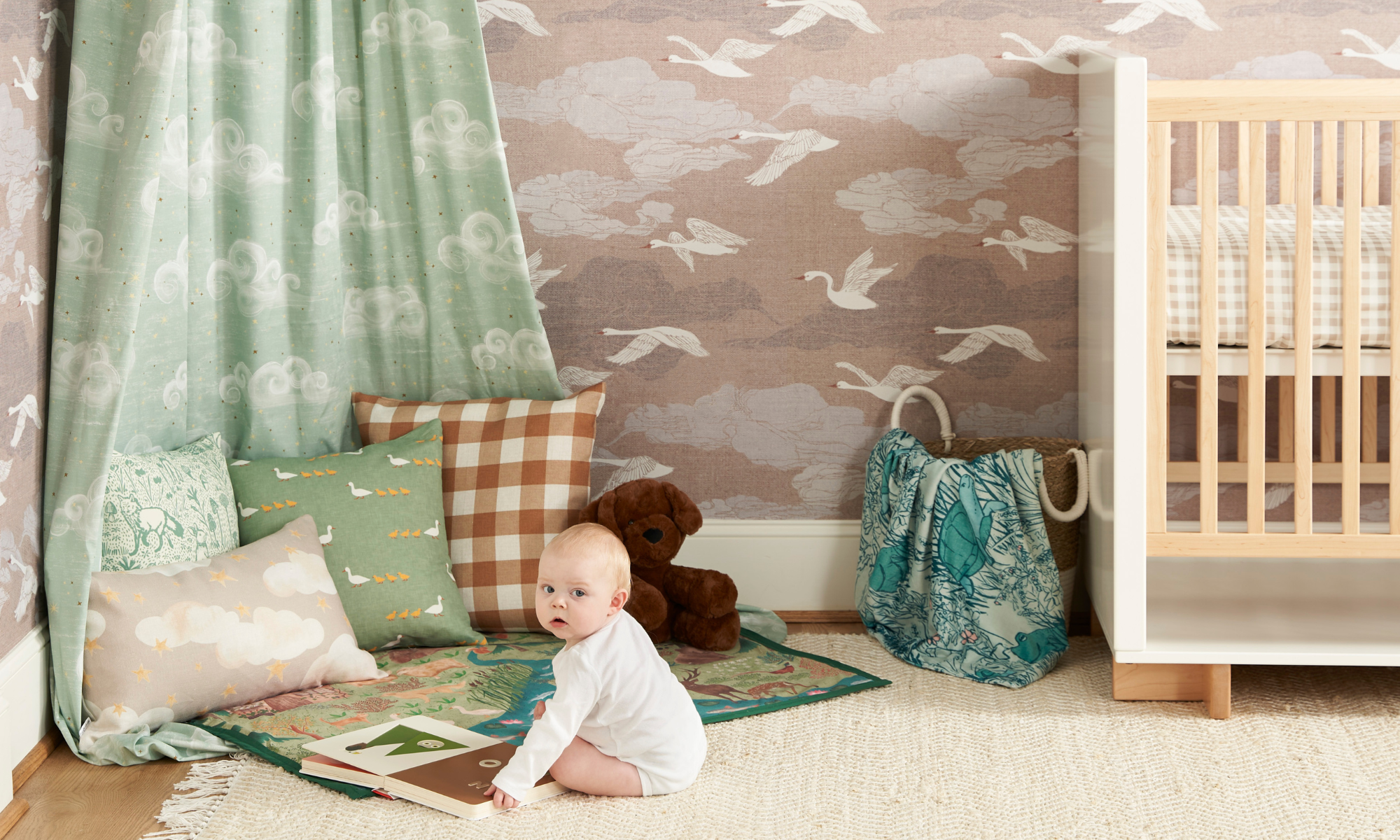 Baby sitting in a swan themed nursery