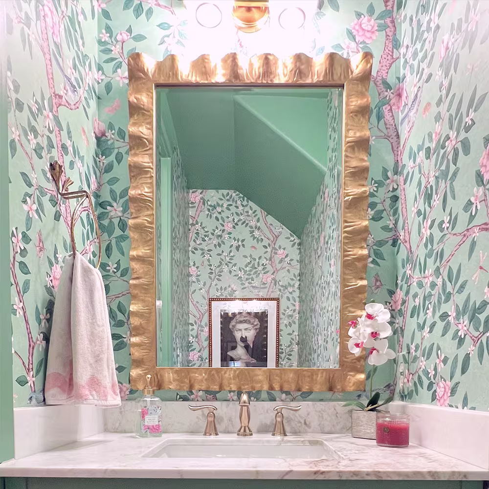 Bathroom with green branch and floral wallpaper.