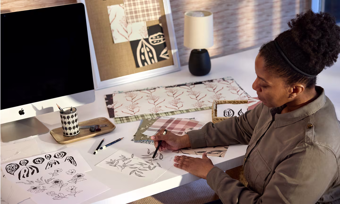 Artist Annette Brown in her studio, sketching botanical designs