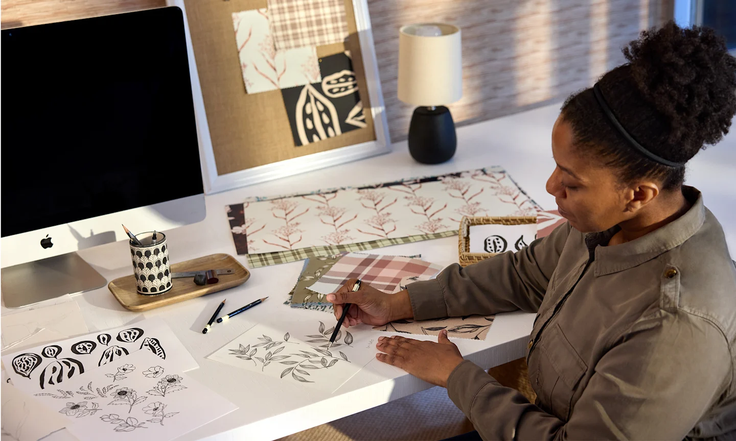 Artist Annette Brown in her studio, sketching botanical designs