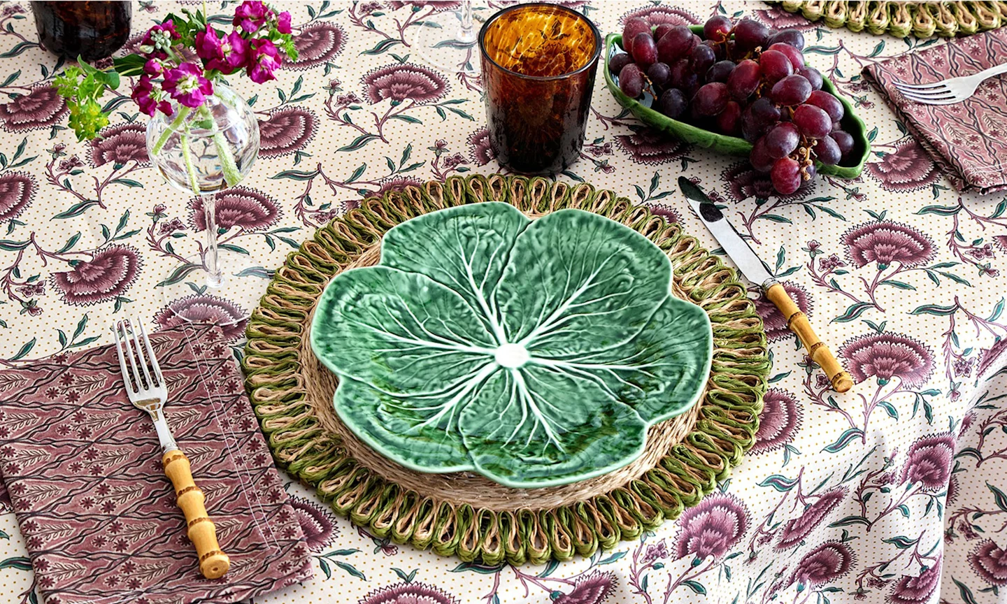 A boho tablescape with table linens in burgundy boho geometrics and vintage florals