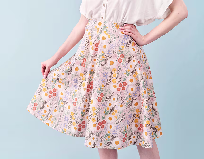 Woman posing in pink spring floral skirt.