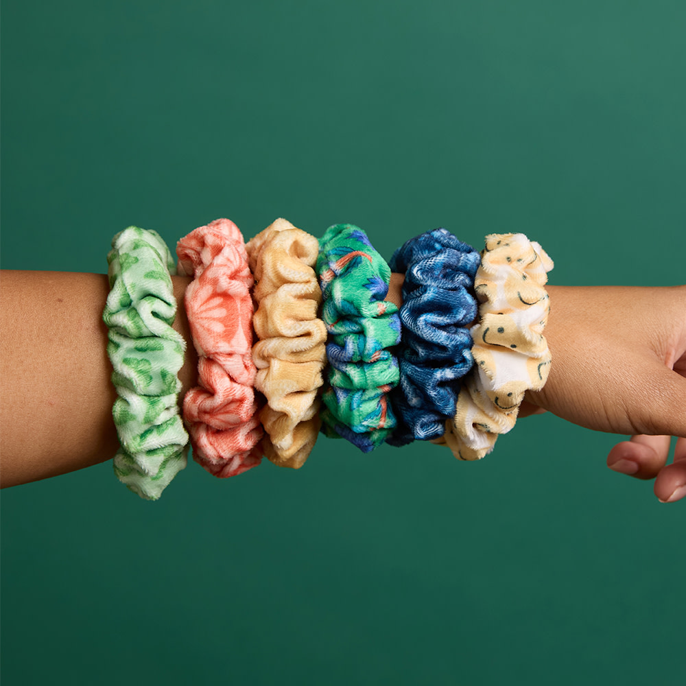 Back of girls head with hair pulled back by multiple colorful scrunchies