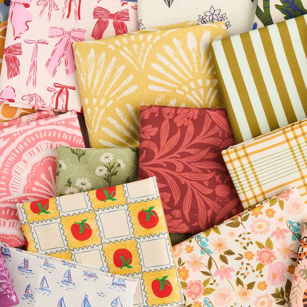 Folded fabrics in assorted colorful patterns arranged in a flat lay