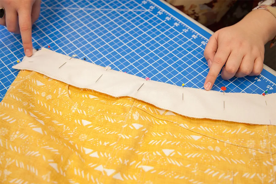 A close up of the second waistband being attached to the skirt using sewing pins.