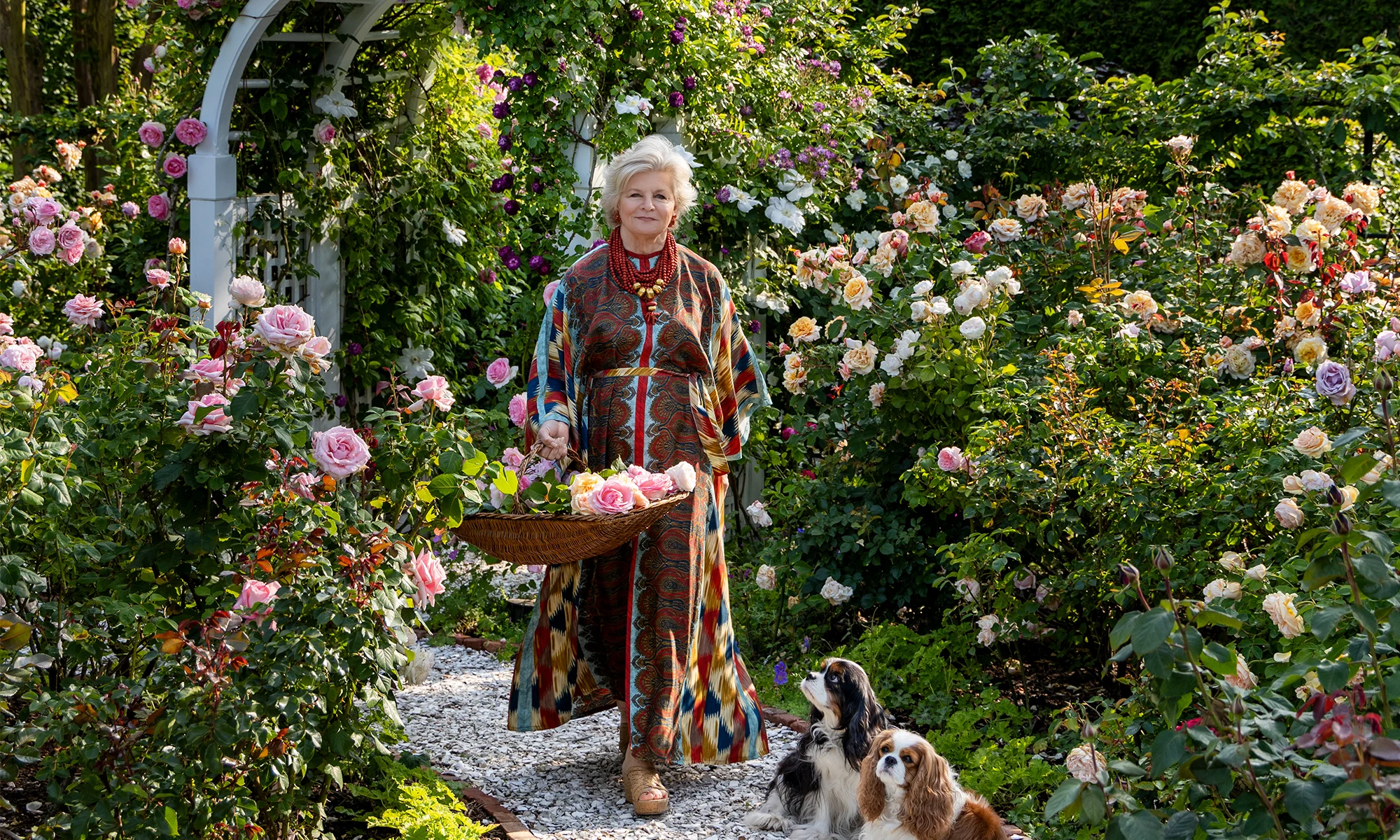 Charlotte Moss in a garden with two dogs.
