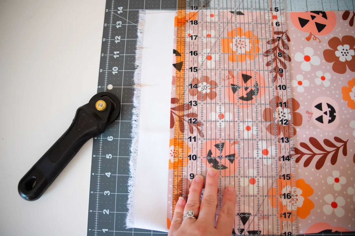 Using a rotary cutter to cut the edges of the fabric to form a rectangle