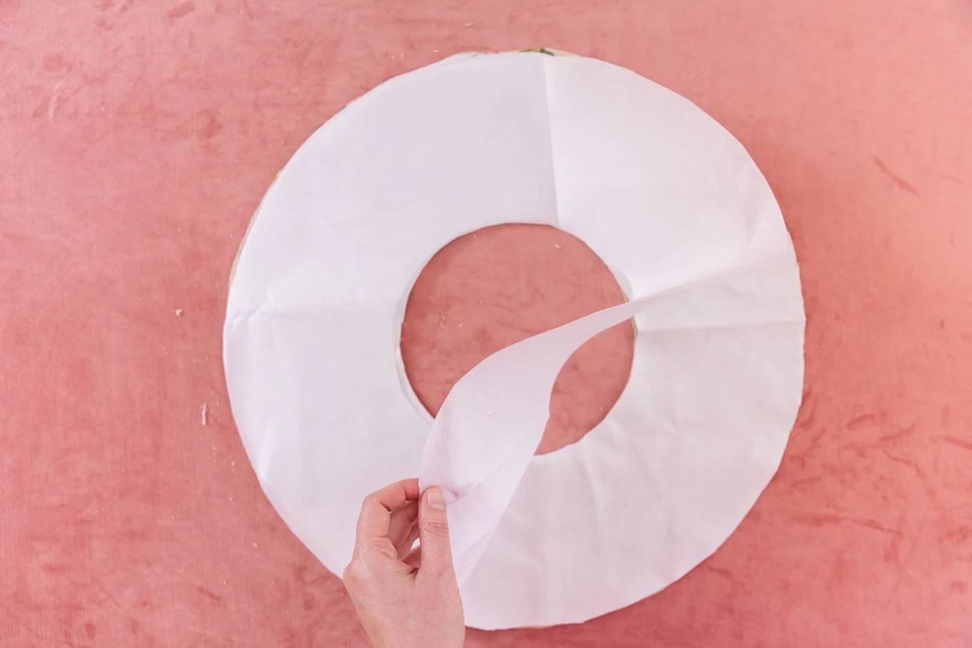 Keiko lifts the heavy interface that is layered on top of the two layers of fabric to indicate the order the pieces should be in before sewing the brim.