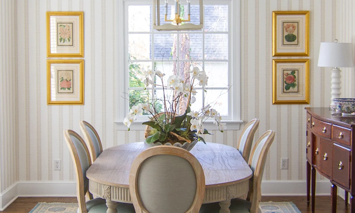 Dining room with cream and tan striped wallpaper.