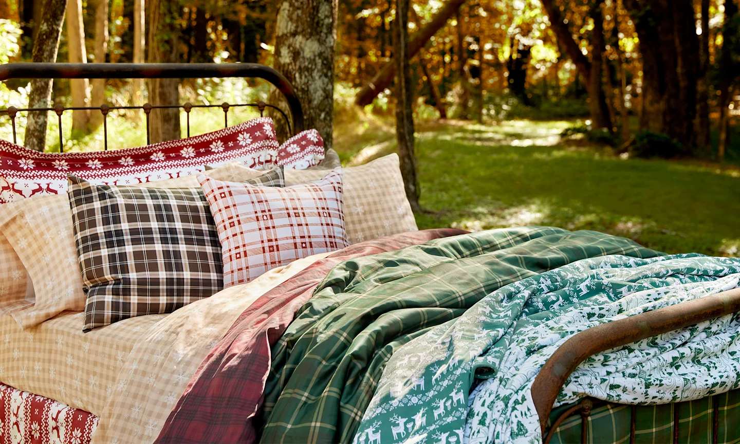 An outdoor scene featuring a bed with holiday bedding